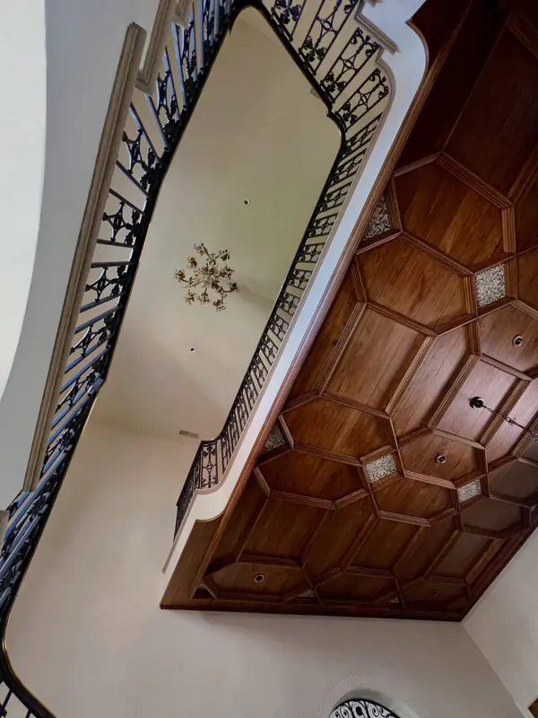 Venetian plaster ceiling above a wrought-iron stair railing and coffered wood landing, Spanish-style home in The Avenues, Salt Lake City