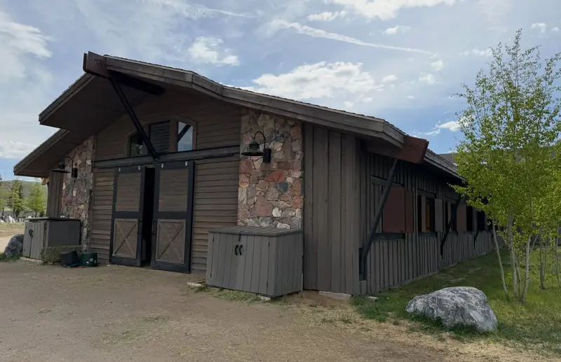 Refinished wood siding and barn doors on a stone outbuilding of the equestrian facility at Promontory, Park City, Utah